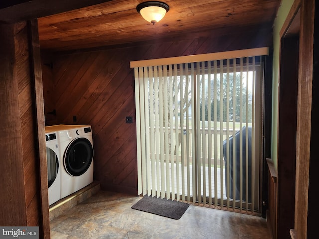 washroom featuring wooden ceiling, washer and clothes dryer, and wood walls