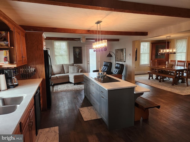 kitchen featuring pendant lighting, black appliances, a center island, and a notable chandelier