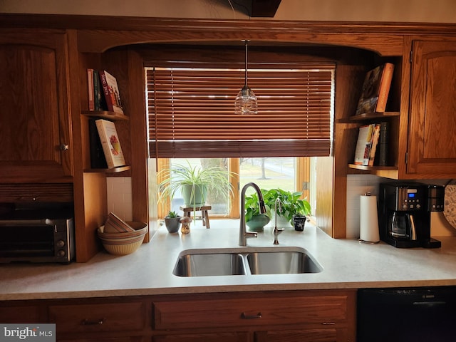 kitchen with tasteful backsplash, decorative light fixtures, dishwasher, and sink