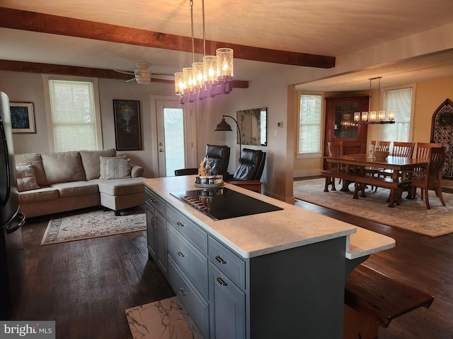 kitchen featuring an inviting chandelier, hanging light fixtures, dark hardwood / wood-style flooring, and black electric stovetop