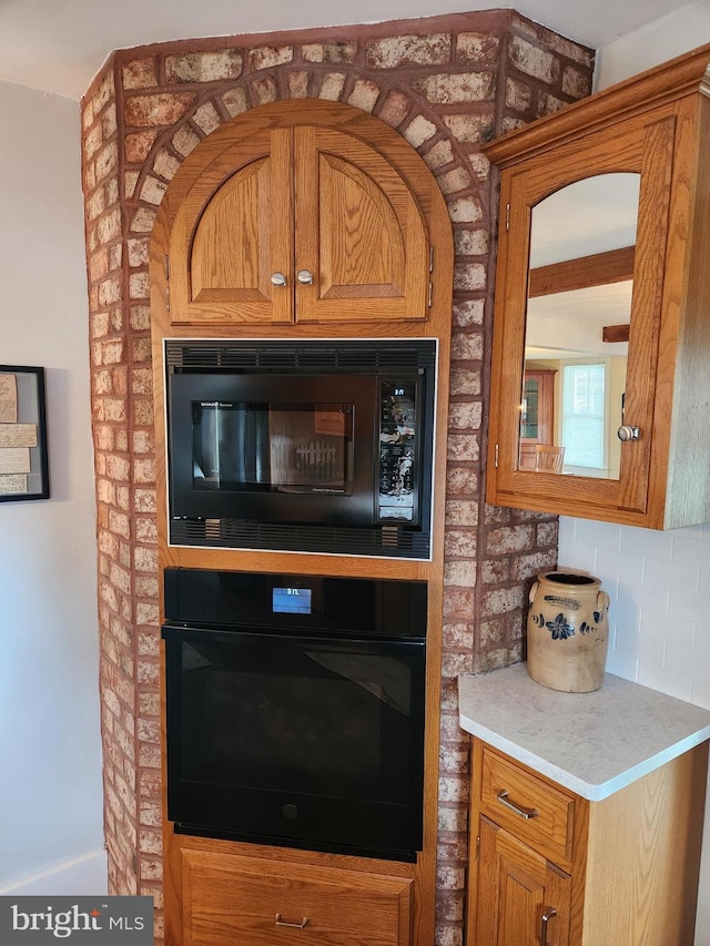 interior details with backsplash and black appliances