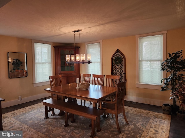 dining area with an inviting chandelier, dark hardwood / wood-style flooring, and plenty of natural light