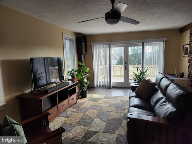 living room featuring ceiling fan, french doors, and a textured ceiling