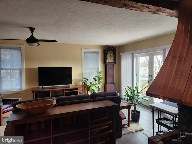 living room with hardwood / wood-style flooring, ceiling fan, and a textured ceiling