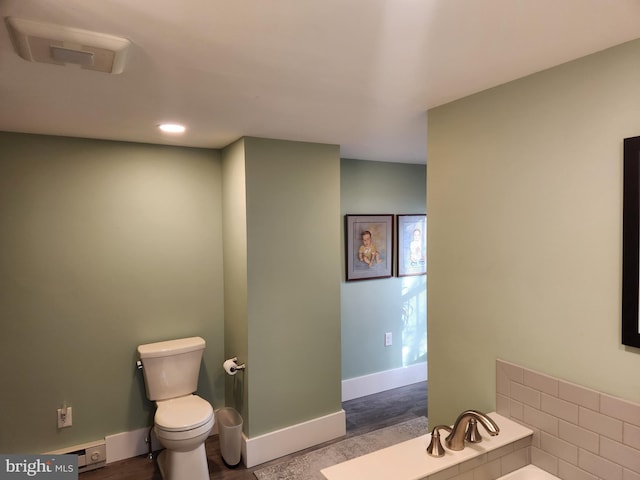 bathroom with toilet and a tub to relax in