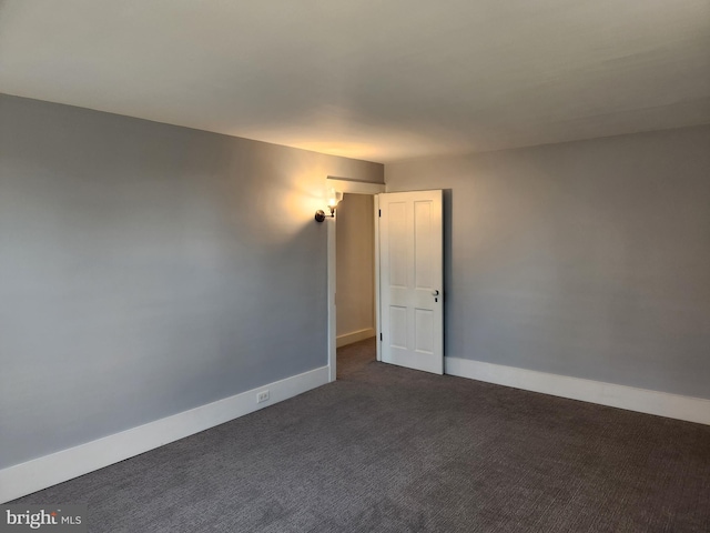 empty room featuring dark carpet