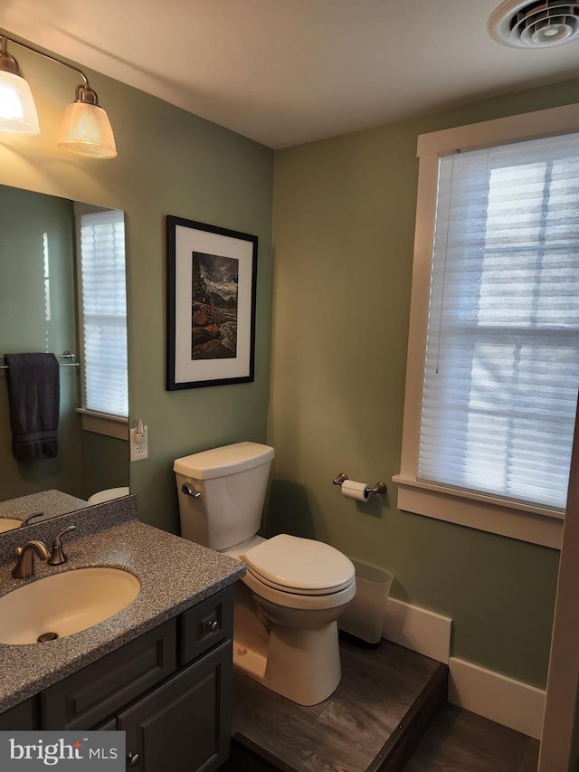 bathroom featuring vanity, toilet, and a wealth of natural light