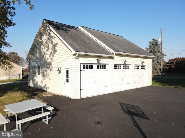 view of side of home featuring a garage and an outdoor structure