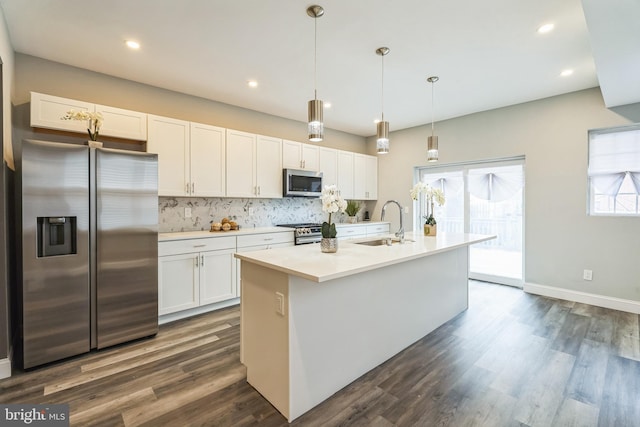 kitchen featuring a kitchen island with sink, sink, white cabinets, and appliances with stainless steel finishes