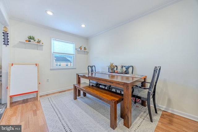 dining area with crown molding and light hardwood / wood-style floors