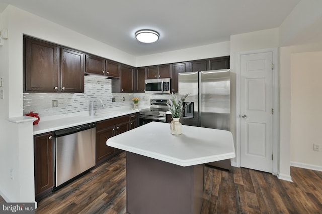 kitchen with sink, stainless steel appliances, dark brown cabinetry, a kitchen island, and decorative backsplash