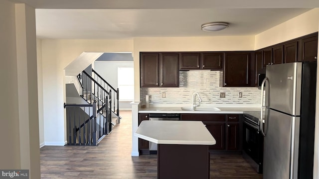 kitchen featuring dark brown cabinetry, sink, appliances with stainless steel finishes, a kitchen island, and decorative backsplash