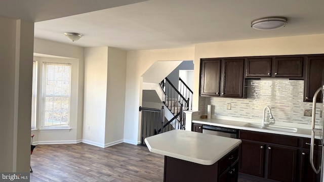 kitchen featuring sink, dark brown cabinets, stainless steel dishwasher, a kitchen island, and a wealth of natural light