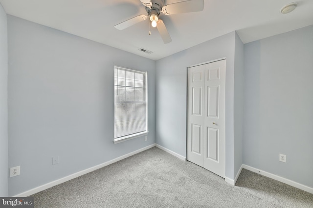 unfurnished bedroom with light carpet, ceiling fan, and a closet