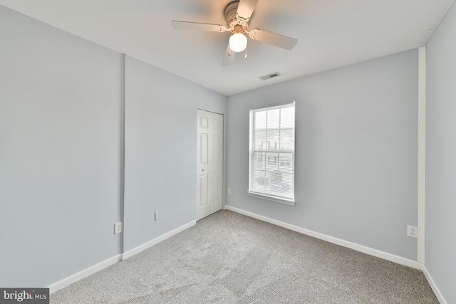 carpeted spare room featuring ceiling fan