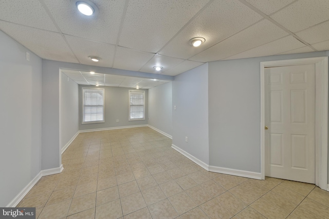 spare room with light tile patterned floors and a drop ceiling