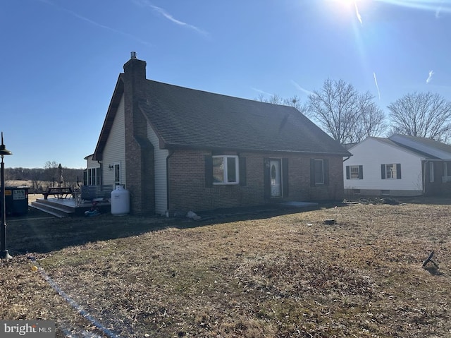 view of front of property with a patio area, brick siding, and a chimney