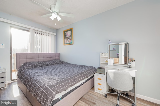 bedroom with ceiling fan, a textured ceiling, and light wood-type flooring