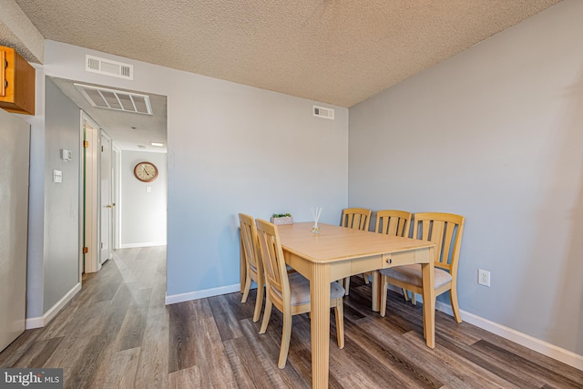 dining room with hardwood / wood-style flooring and a textured ceiling