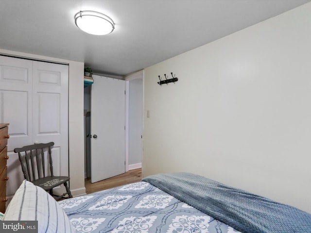 bedroom with hardwood / wood-style floors and a closet