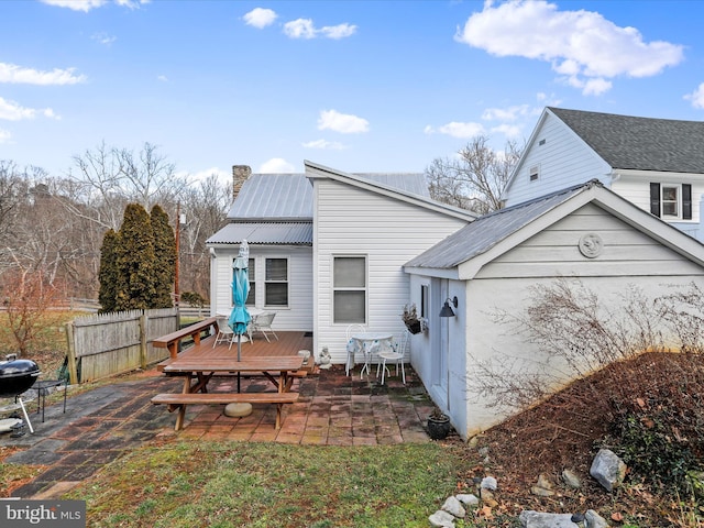 rear view of house with a wooden deck and a patio area