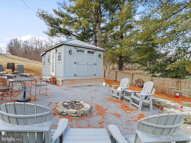 view of patio / terrace with an outdoor fire pit and a storage unit