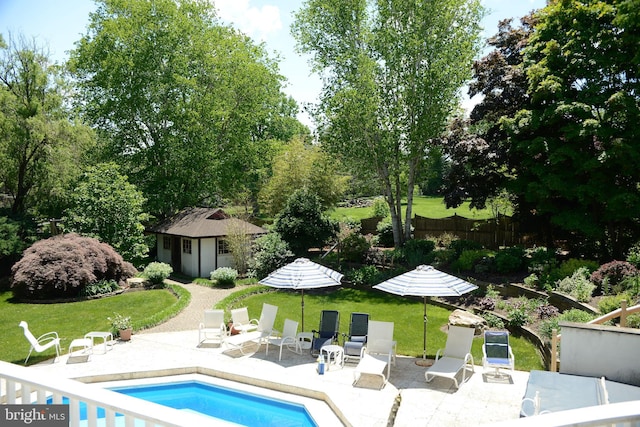 view of swimming pool with an outdoor structure, a patio, and a lawn