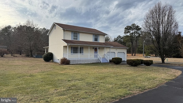 view of front of home featuring a garage, a front yard, and a porch