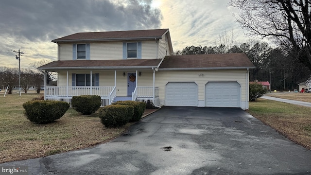 front facade featuring a porch, a garage, and a front lawn