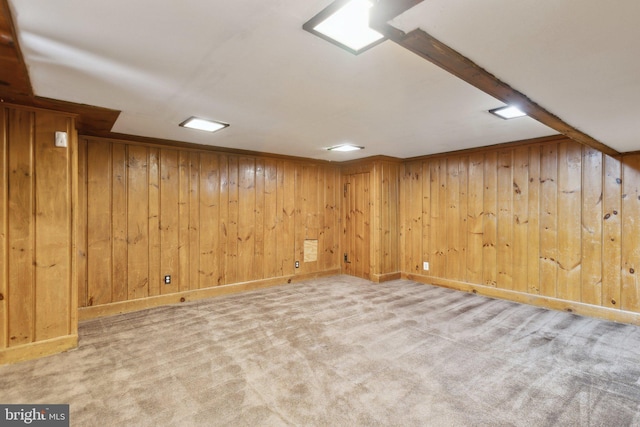 basement with light colored carpet and wood walls