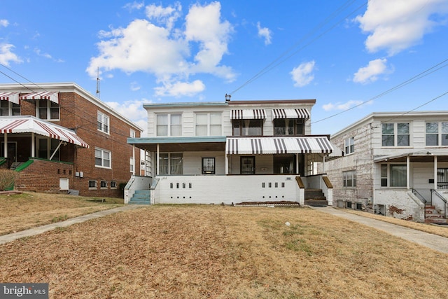 view of front of house with covered porch and a front lawn