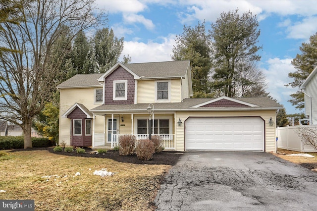 view of property featuring a garage, a porch, and a front yard