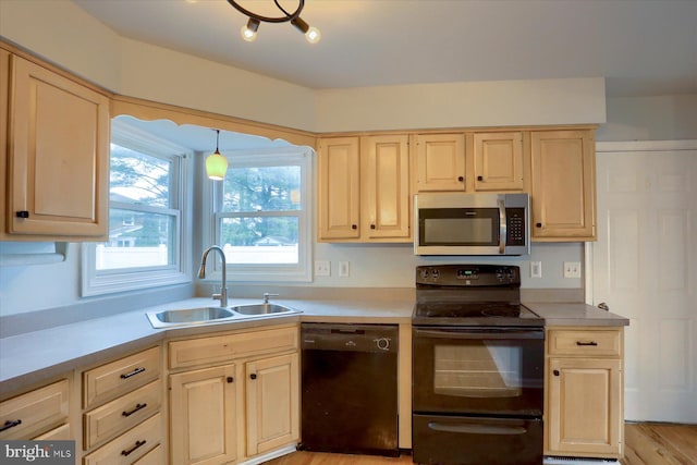 kitchen with pendant lighting, sink, black appliances, and light brown cabinets