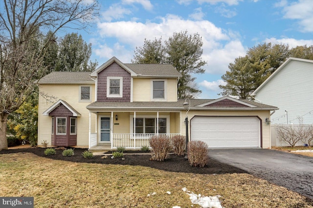 view of property with a garage, a front lawn, and a porch