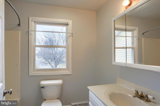 bathroom with vanity, plenty of natural light, walk in shower, and toilet