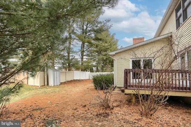 view of yard featuring a deck and a storage unit