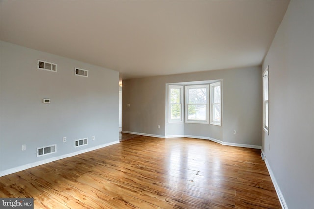 empty room with light hardwood / wood-style flooring