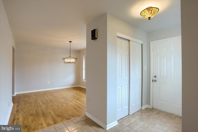 tiled entryway with an inviting chandelier