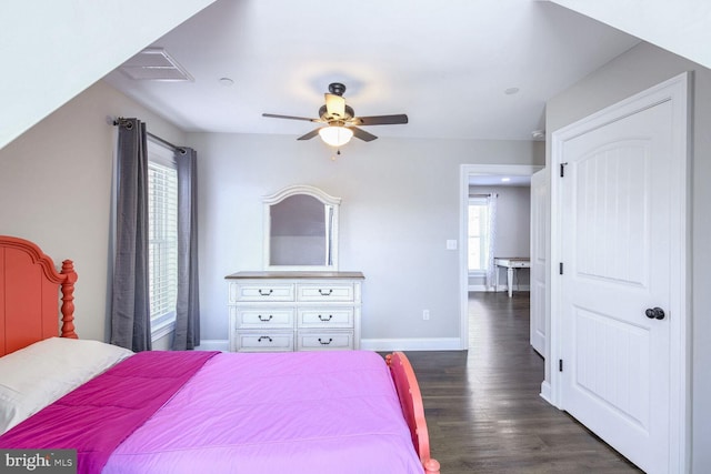 bedroom with dark wood-type flooring, ceiling fan, and multiple windows