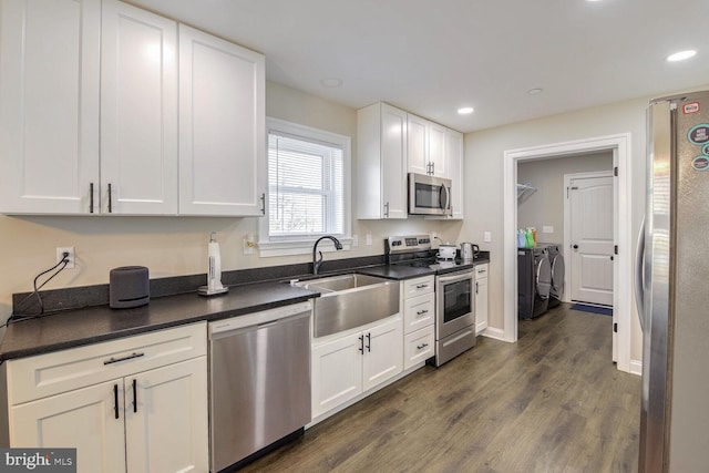 kitchen with white cabinetry, stainless steel appliances, sink, and washer and dryer