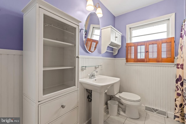 bathroom with sink, toilet, and tile patterned flooring