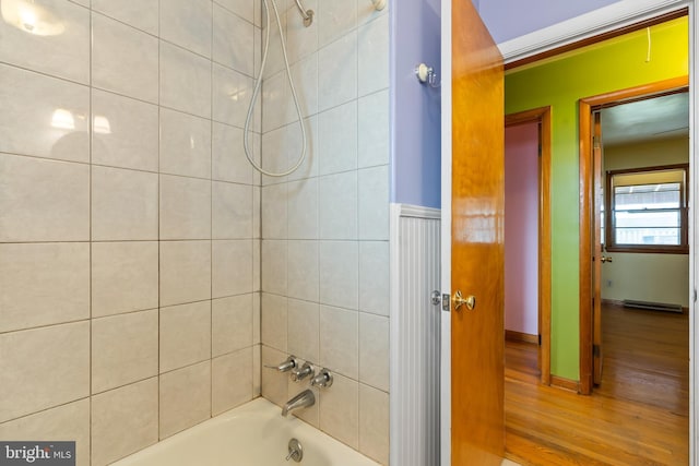 bathroom featuring baseboard heating, tiled shower / bath, and wood-type flooring