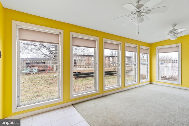 unfurnished sunroom with ceiling fan