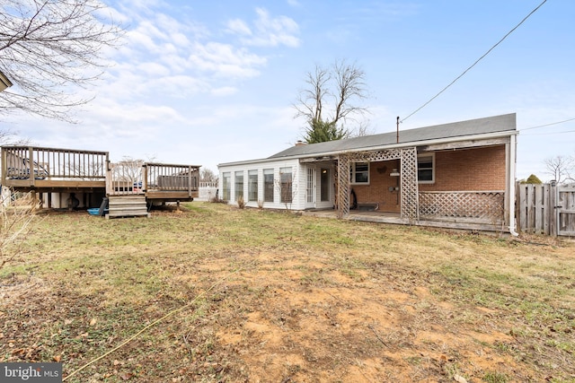 rear view of property with a yard and a deck