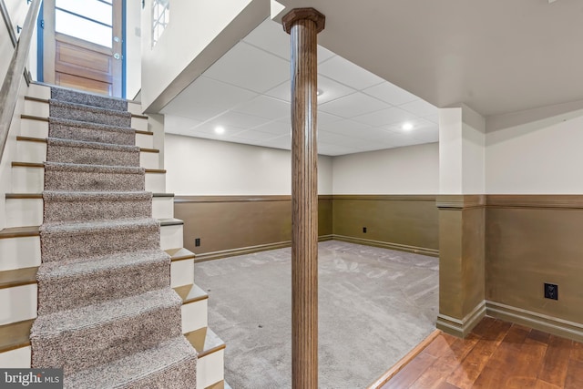 basement featuring a drop ceiling and hardwood / wood-style floors