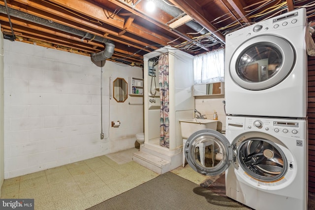 laundry room with stacked washing maching and dryer and sink