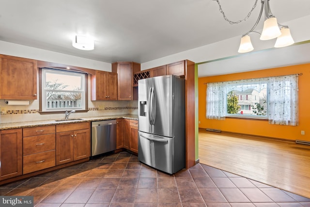 kitchen with sink, decorative light fixtures, decorative backsplash, and appliances with stainless steel finishes