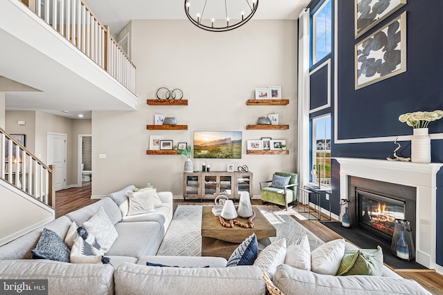 living room featuring a high ceiling, wood-type flooring, and a chandelier