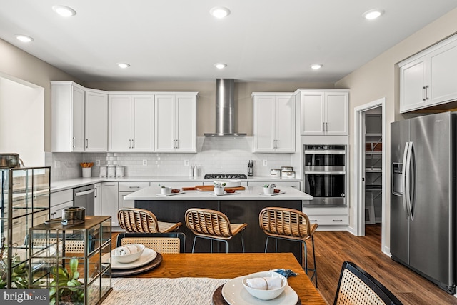 kitchen featuring appliances with stainless steel finishes, white cabinets, and wall chimney exhaust hood