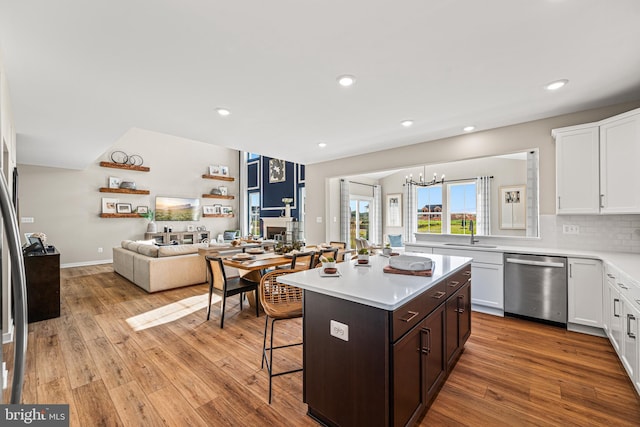 kitchen with white cabinetry, a kitchen breakfast bar, stainless steel dishwasher, and a center island